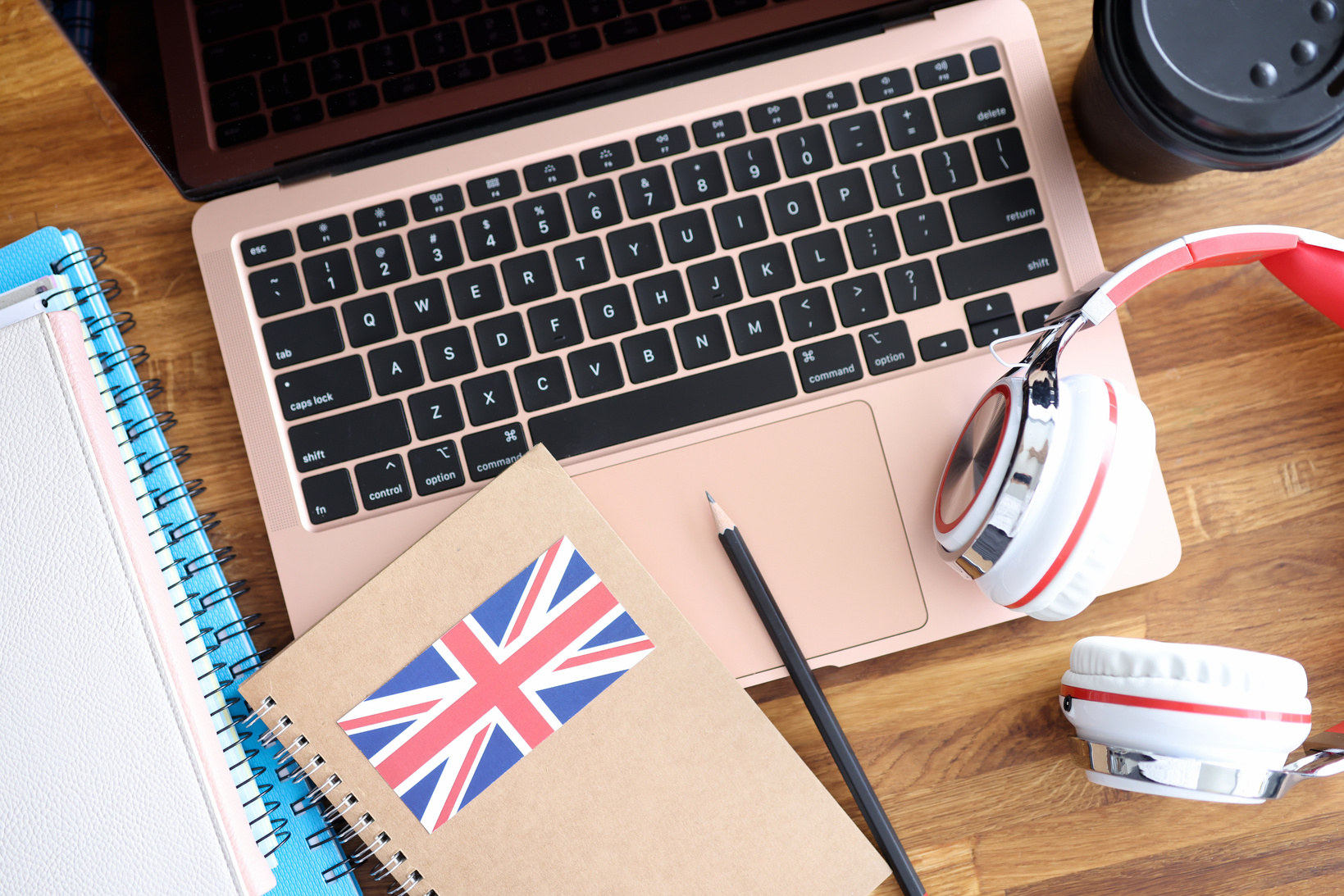 Headphones and English Textbooks Lying on Laptop Keyboard Closeu